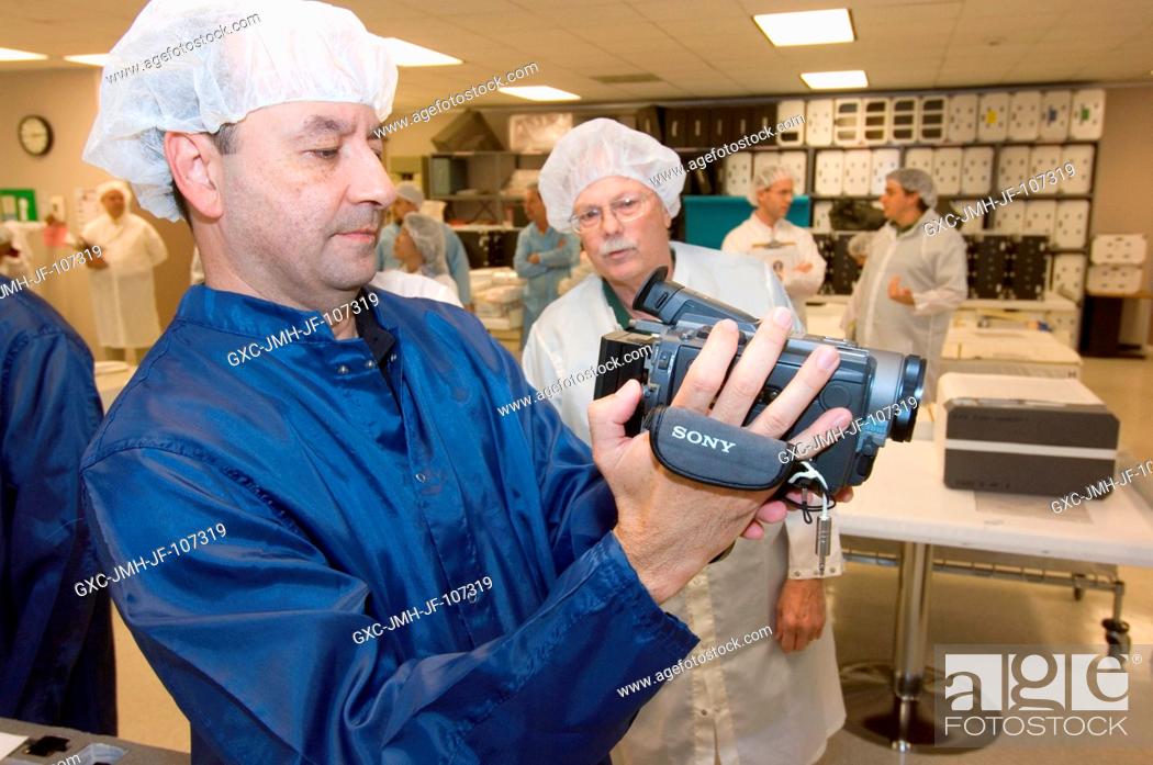 Stock Photo: Astronaut Mark L. Polansky, STS-116 commander, inspects camera equipment during a crew equipment bench review in an offsite facility near Johnson Space Center.