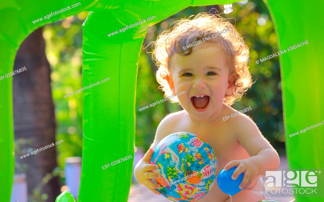 Stock Photo: Laughing little girl play in the small pool.