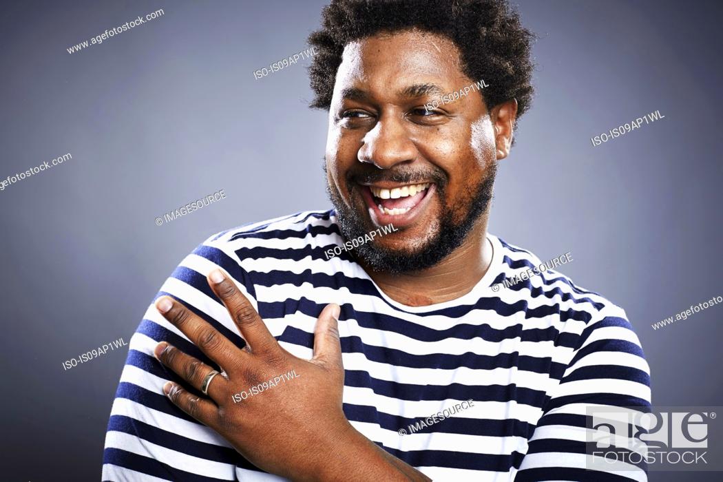 Imagen: Studio portrait of mid adult man laughing.