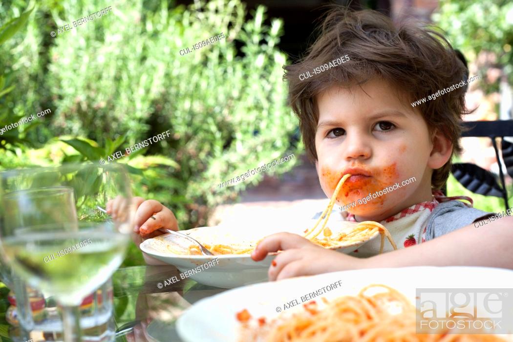 Stock Photo: Portrait of messy male toddler eating spaghetti.