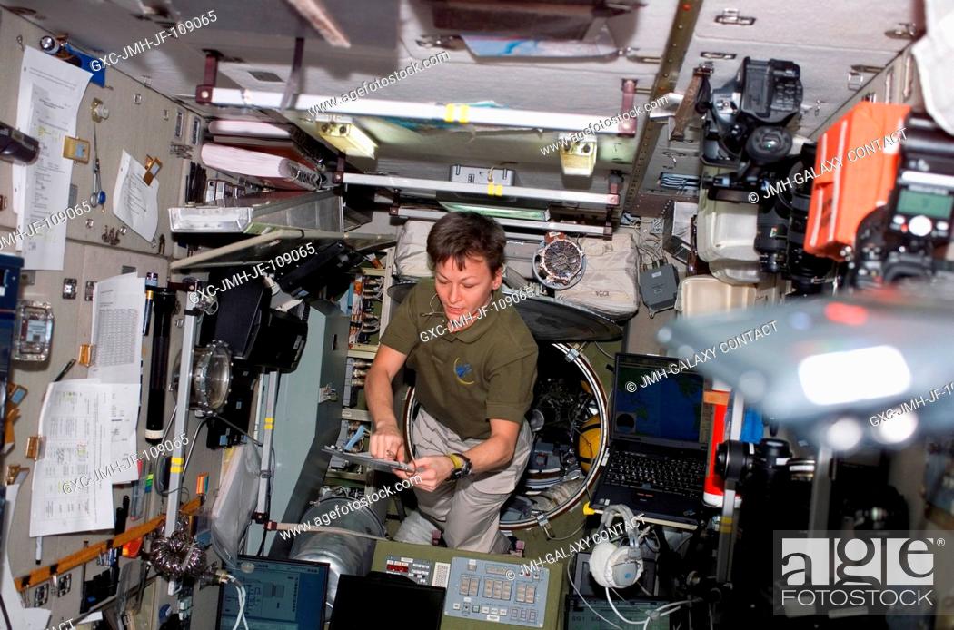 Stock Photo: Astronaut Peggy Whitson, Expedition 16 commander, looks over a checklist in the Zvezda Service Module of the International Space Station while Space Shuttle.