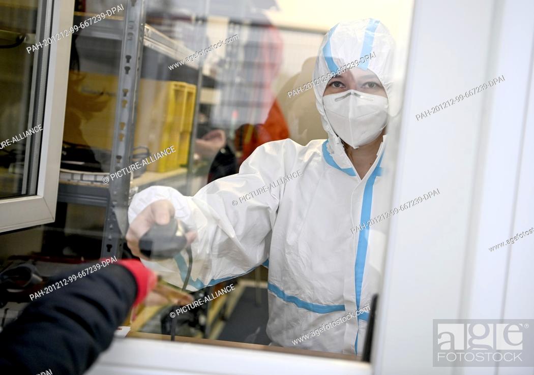 Stock Photo: 11 December 2020, Berlin: A young woman registers for a SARS-CoV-2 antigen test at the Corona Antigen Rapid Test Centre at Mauerpark in the Berlin district of.