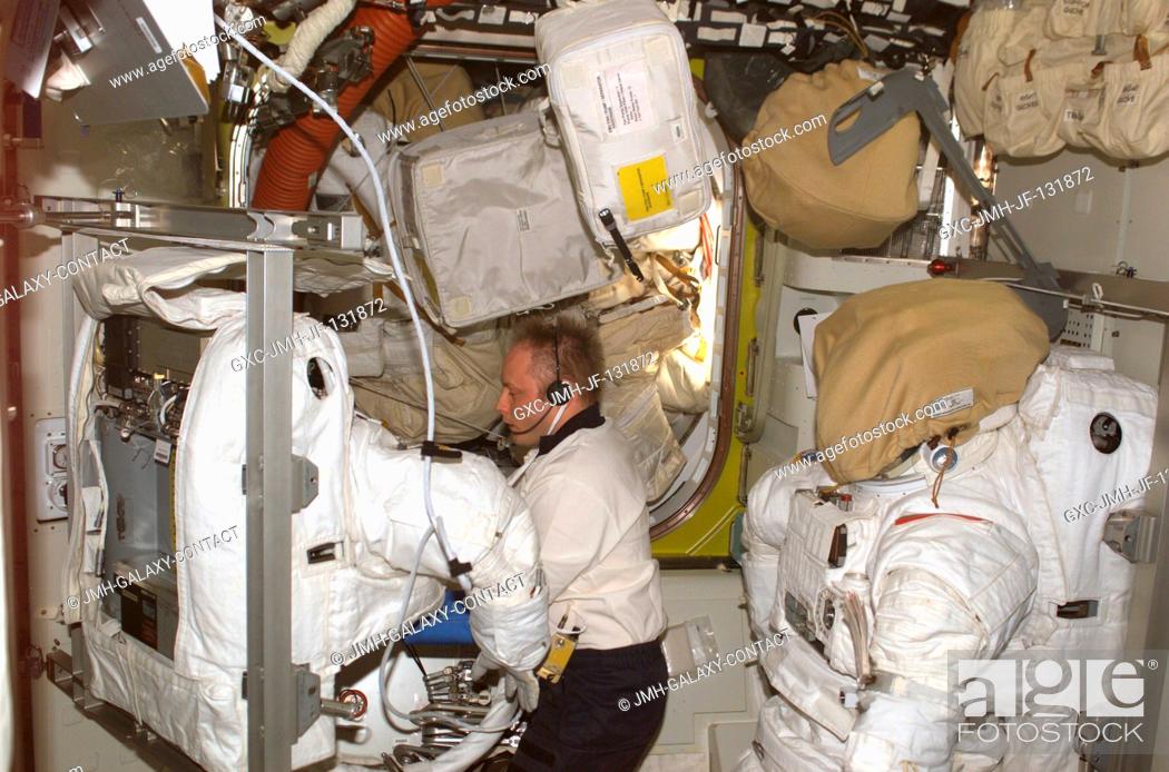 Stock Photo: Astronaut Edward M. (Mike) Fincke, Expedition 9 NASA ISS science officer and flight engineer, performs maintenance on an Extravehicular Mobility Unit (EMU).