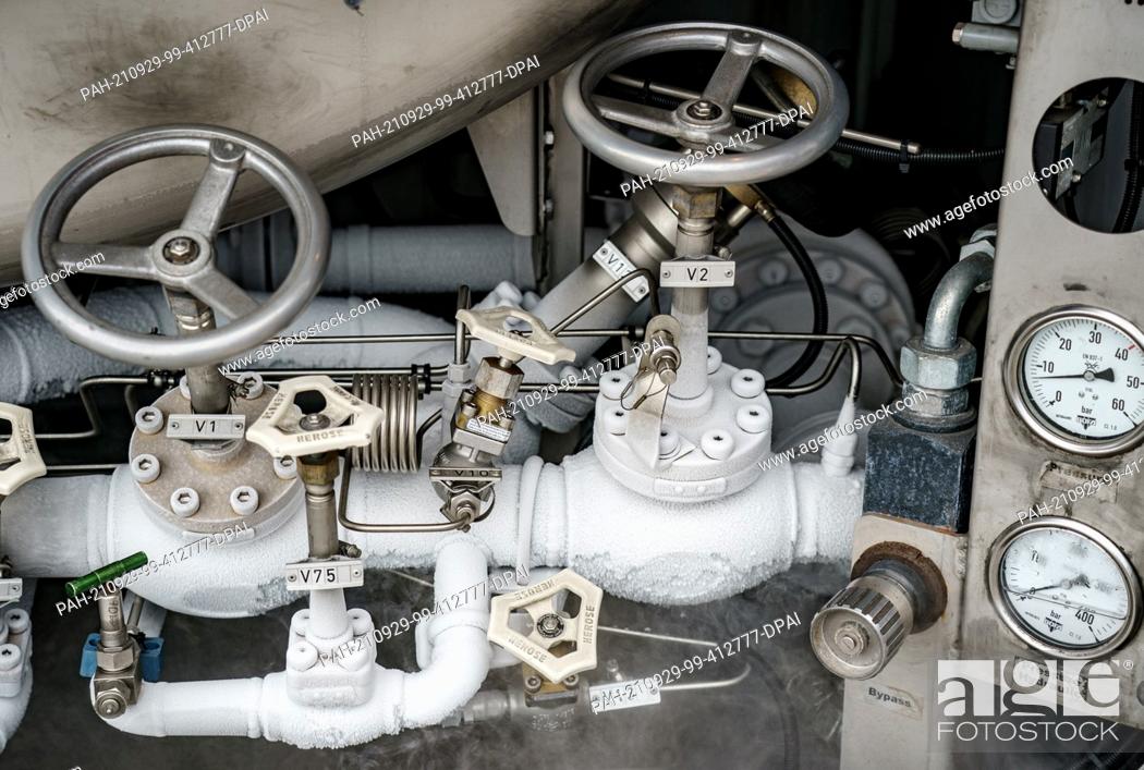 Stock Photo: 29 September 2021, Schleswig-Holstein, Brunsbüttel: The valves of the connections for LNG refuelling iced up on a tanker in the Elbe port during the refuelling.