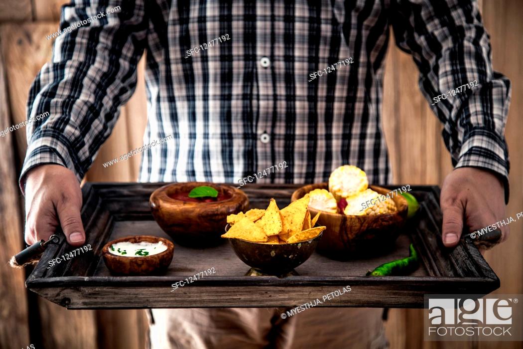 Stock Photo: Man with snacks and dips (Mexican food).