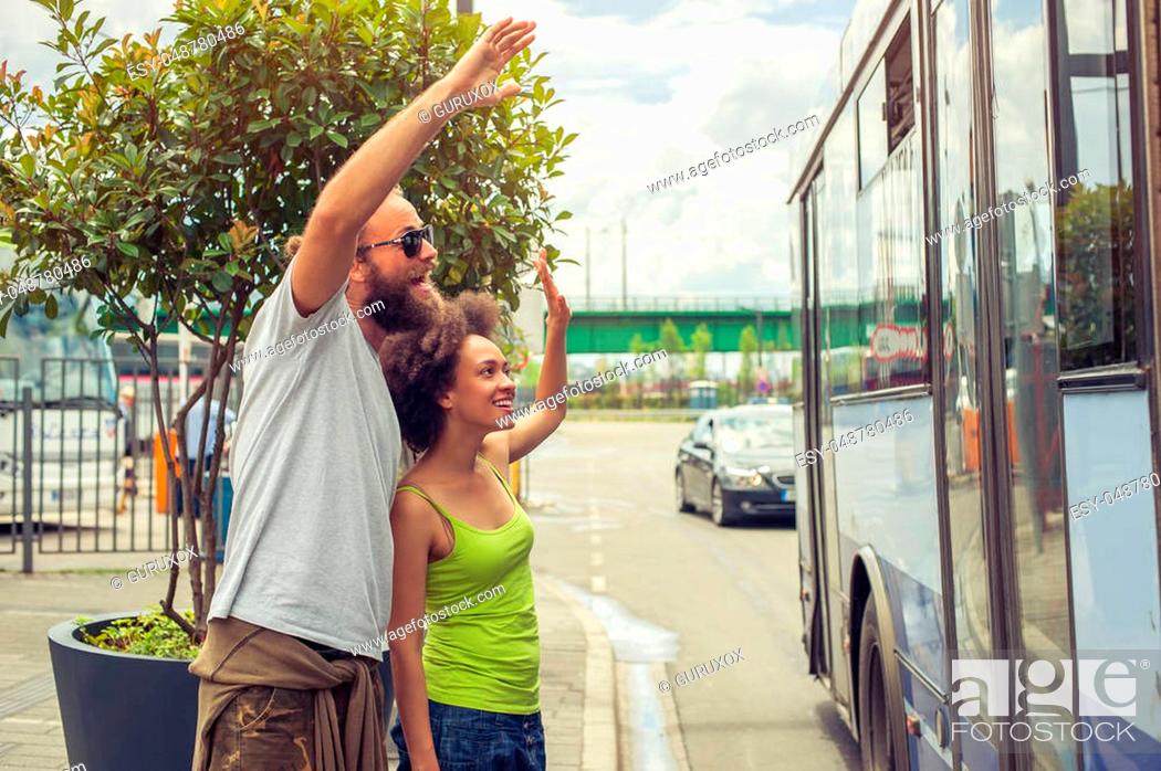 Stock Photo: Young couple waving goodbye to their friends on the bus at bus station.