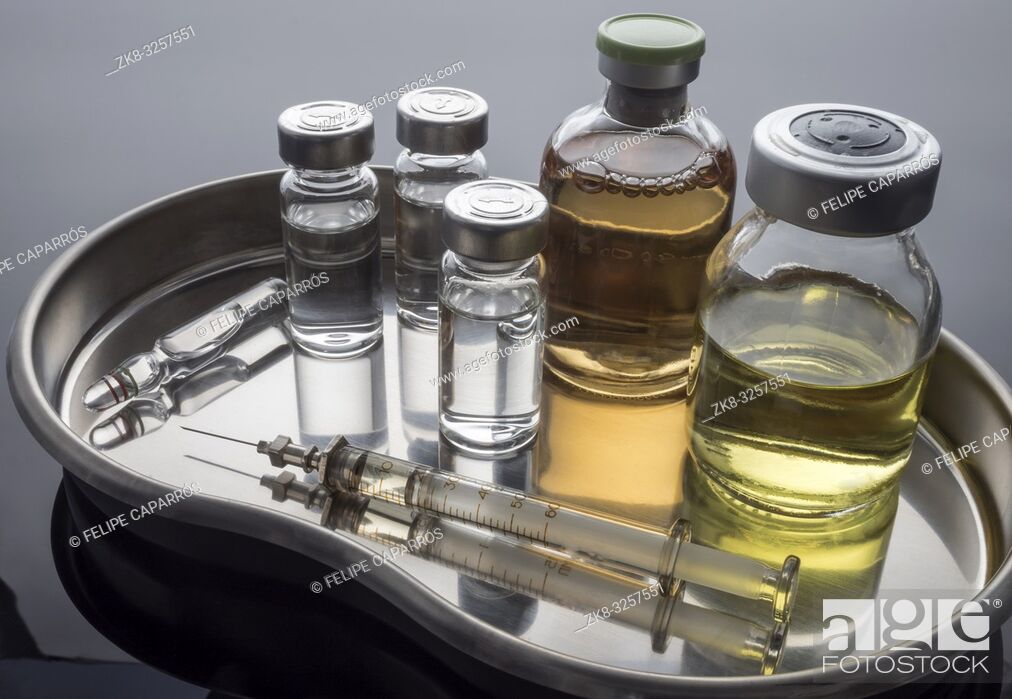 Stock Photo: Vintage syringe next to vials with medication, conceptual image, horizontal composition.
