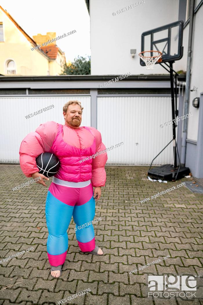 Stock Photo: Portrait of a man with basketball wearing pink bodybuilder costume.