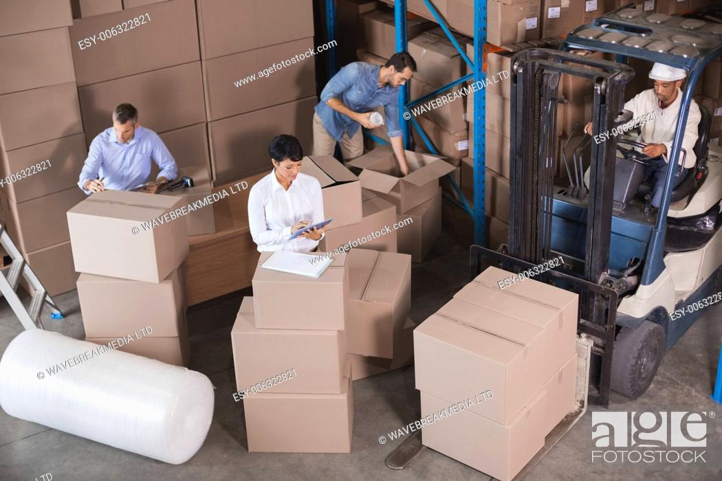 Stock Photo: Warehouse workers preparing a shipment in a large warehouse.
