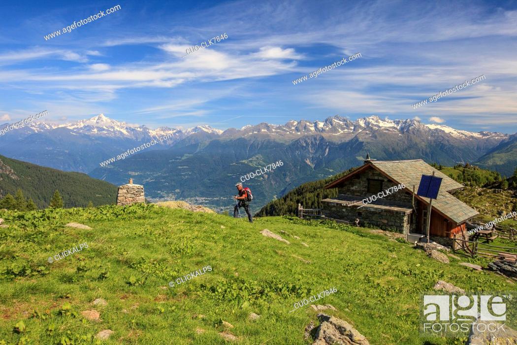 Stock Photo: Hiker leaves the hut and proceeds in a summer sunny day, Orobie Alps, Arigna Valley, Valtellina, Lombardy, Italy, Europe.