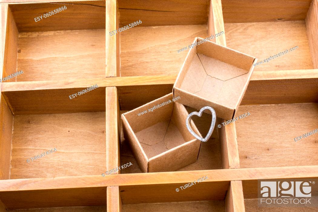 Stock Photo: Open cardboard box inside a wooden box with compartments and a heart.