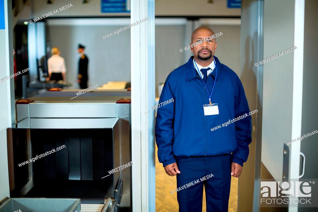 Stock Photo: Airport security officer standing in metal detector door.