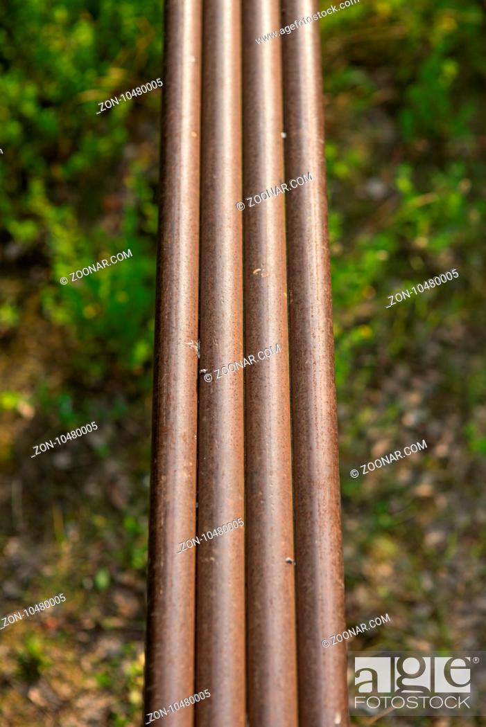 Stock Photo: Water metal steel rusty pipes on forest background full of foliage grass and bushes. selective focus macro shot with shallow DOF.