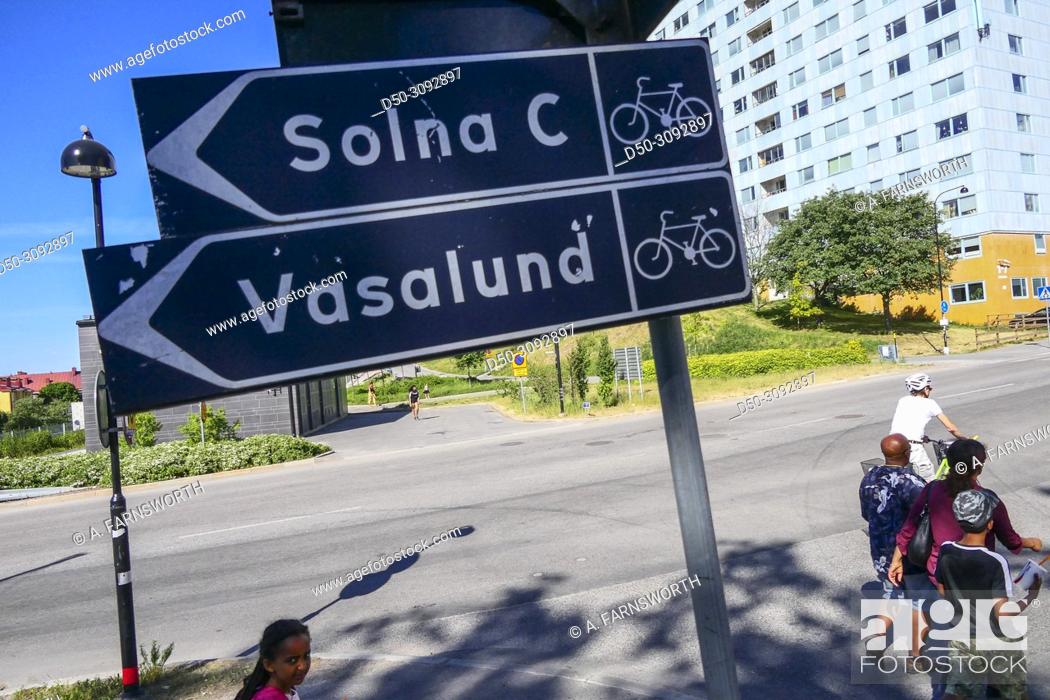 Stock Photo: Family walk by a sign to Solna, Hagalund, Solna suburb. Stockholm, Sweden.