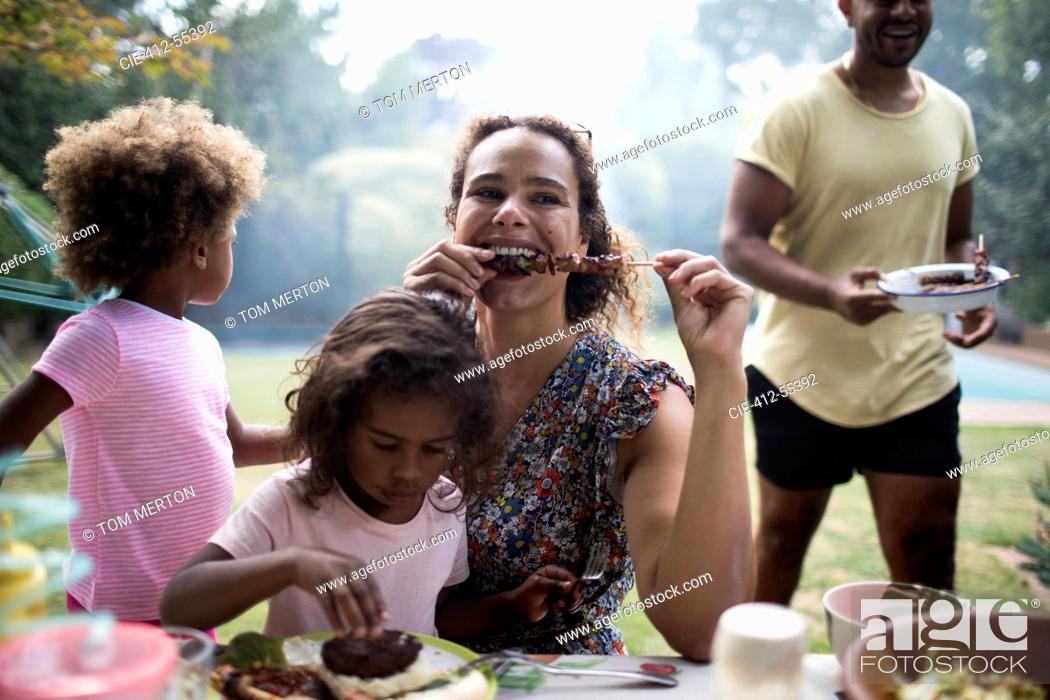 Stock Photo: Mother and daughter enjoying barbecue lunch on patio.