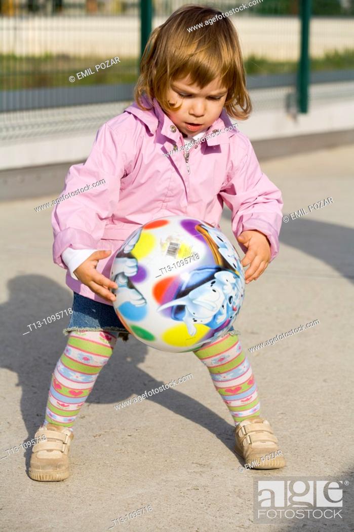 Photo de stock: Playful female toddler with a ball.