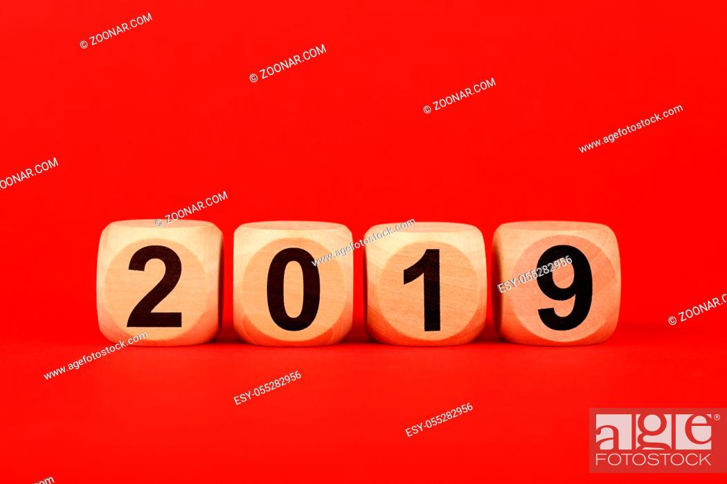 Imagen: Close up wooden cube signs with 2019 word over red background with copy space, elevated top view, directly above.