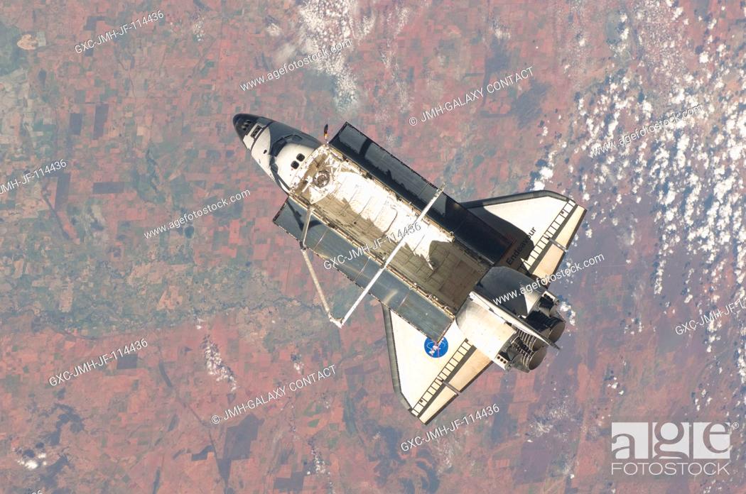 Stock Photo: Backdropped by a colorful part of Earth, the space shuttle Endeavour is featured in this image photographed by an Expedition 22 crew member on the International.