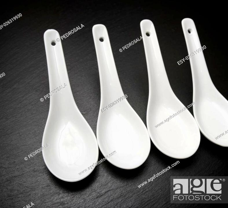Stock Photo: four small white spoons on a table slate.