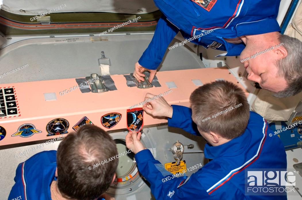 Stock Photo: In the Unity node, Expedition 28 crew members add the Expedition 28 patch to the growing collection of insignias representing crews who have worked on the.