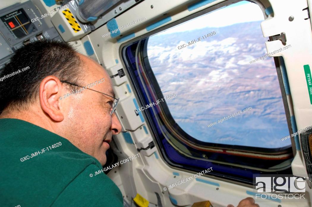 Stock Photo: Astronaut Mark Polansky, STS-127 commander, looks through a window on the aft flight deck of the Earth-orbiting Space Shuttle Endeavour during flight day 15.