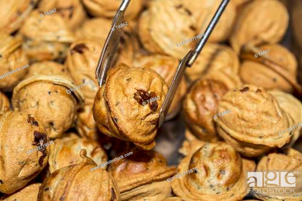 Stock Photo: Chinese walnut filled muffin being held by a set of prongs.