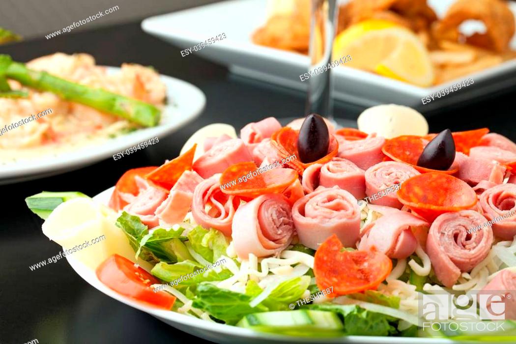 Stock Photo: A delicious looking tossed chefs salad or antipasto with meat cheese and kalamata olives.