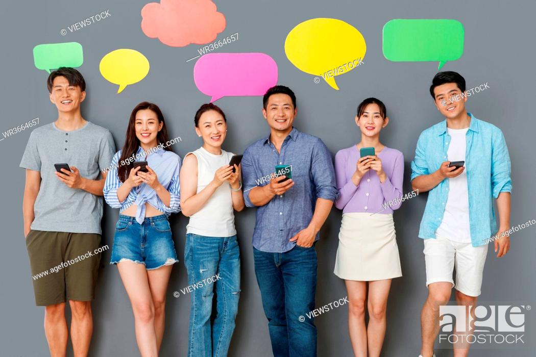 Stock Photo: In the happy young people use mobile phone chat software to communicate.
