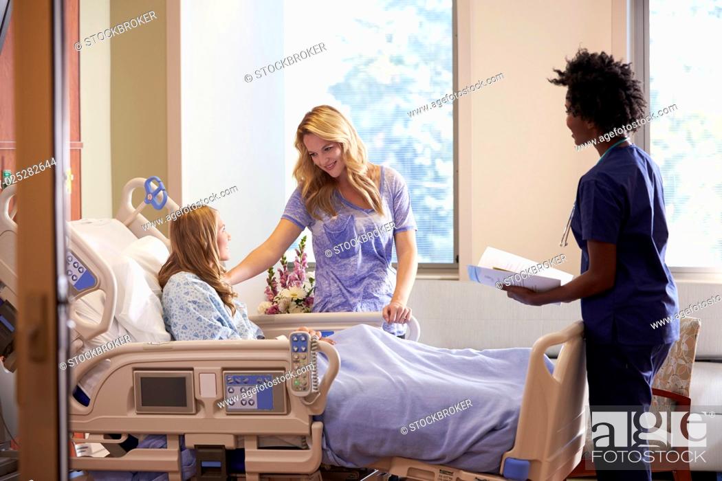 Stock Photo: Nurse Talks To Mother With Teenage Daughter In Hospital.