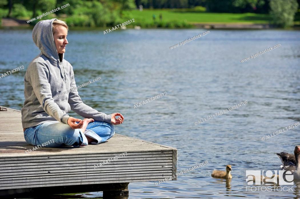 Stock Photo: Woman making yoga on a landing stage.
