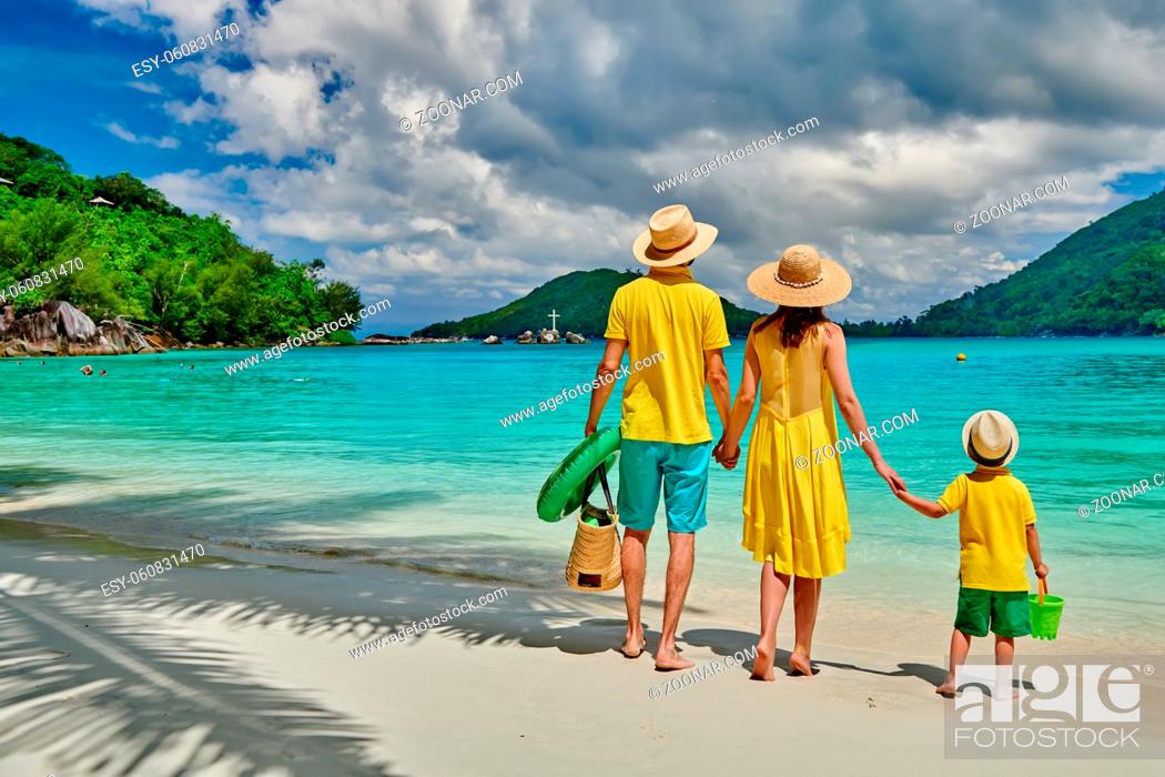 Stock Photo: Family on beach, young couple in yellow with three year old boy. Summer vacation at Seychelles. Port Launay, Mahe.