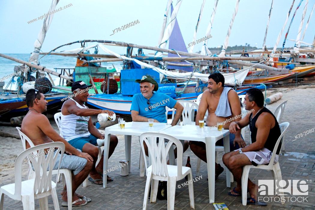 Stock Photo: Fishermen having a beer break with their jangadas boats at the beach in Iguape, Fortaleza district, Brazil.