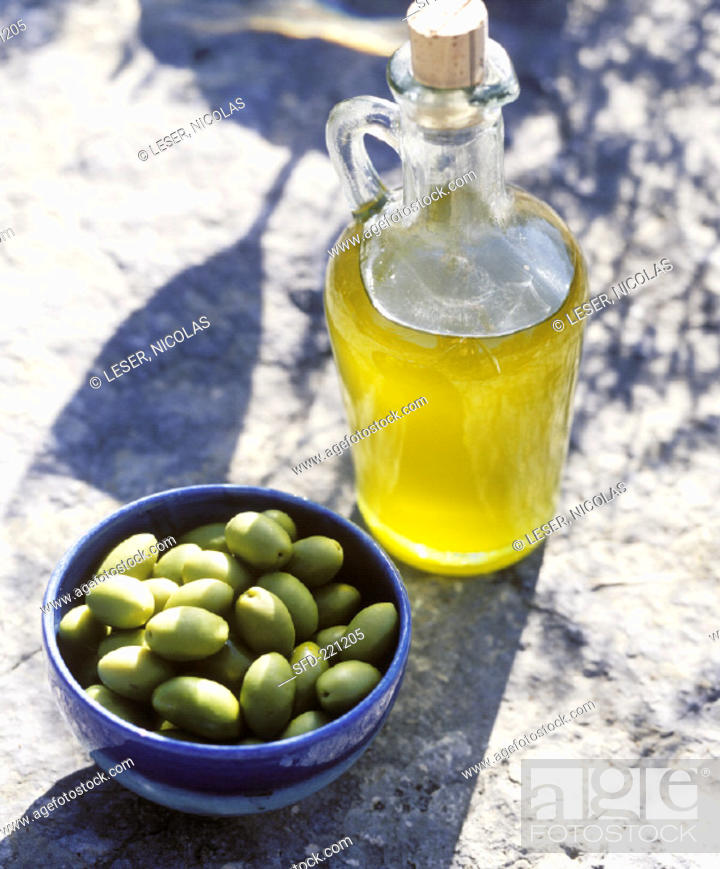 Stock Photo: Olive oil & a bowl of green olives on stone background (2).