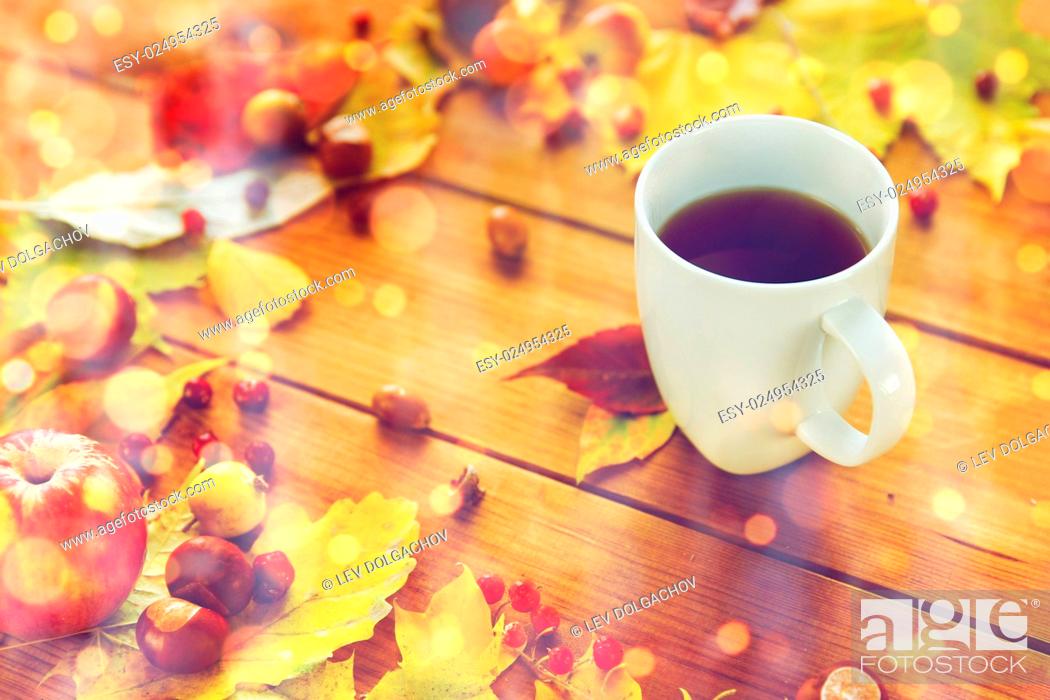 Stock Photo: season, drink and morning concept - close up of tea cup on wooden table with autumn leaves.