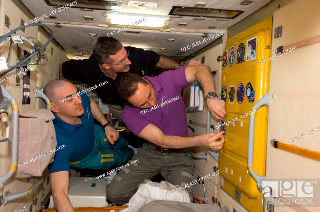 Stock Photo: In the Zarya Functional Cargo Block (FGB), NASA astronaut Dan Burbank (center), Expedition 30 commander; along with Russian cosmonauts Anton Shkaplerov (right).