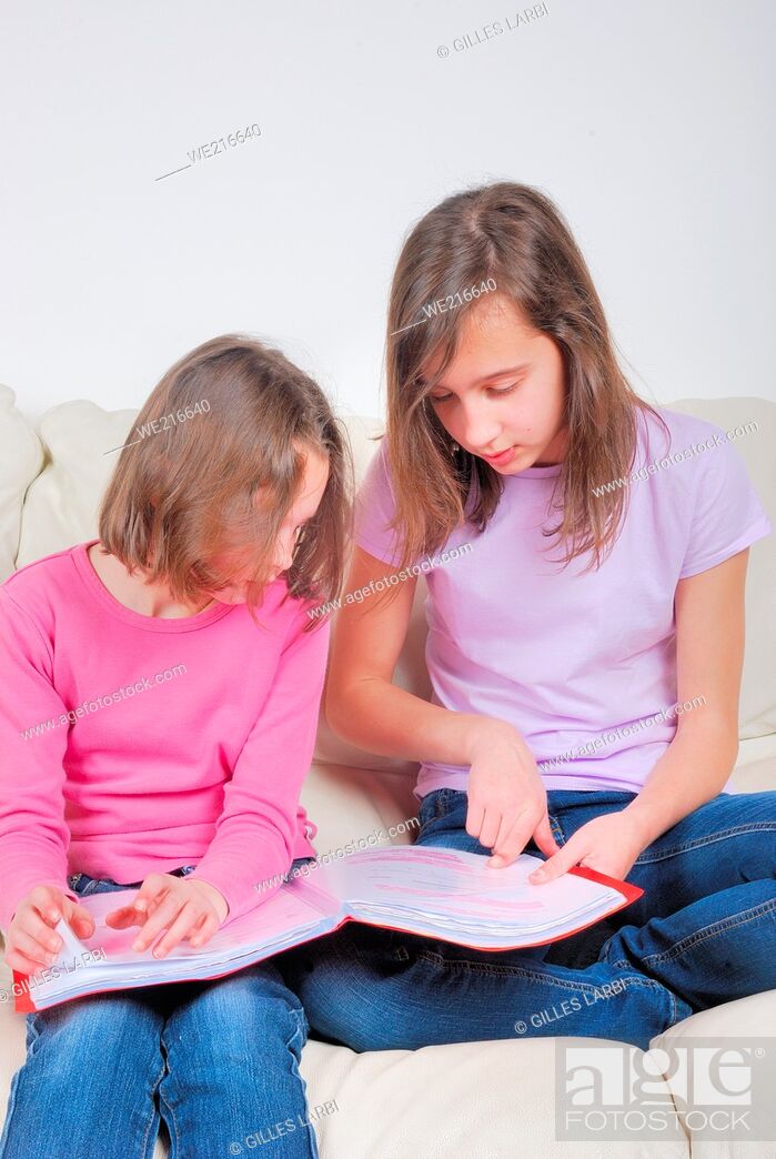 Photo de stock: Two sisters student on the couch with a notebook.