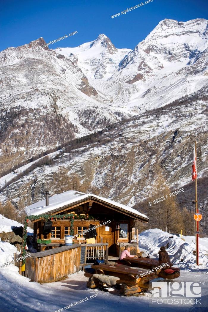 Imagen: People sitting in front of Fondue Hut of the restaurant Hohnegg, Saas-Fee, Valais, Switzerland.