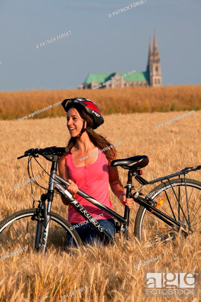 Photo de stock: BICYCLE TOURISTS IN A WHEAT FIELD NEAR THE CHARTRES CATHEDRAL, EURE-ET-LOIR 28, FRANCE.