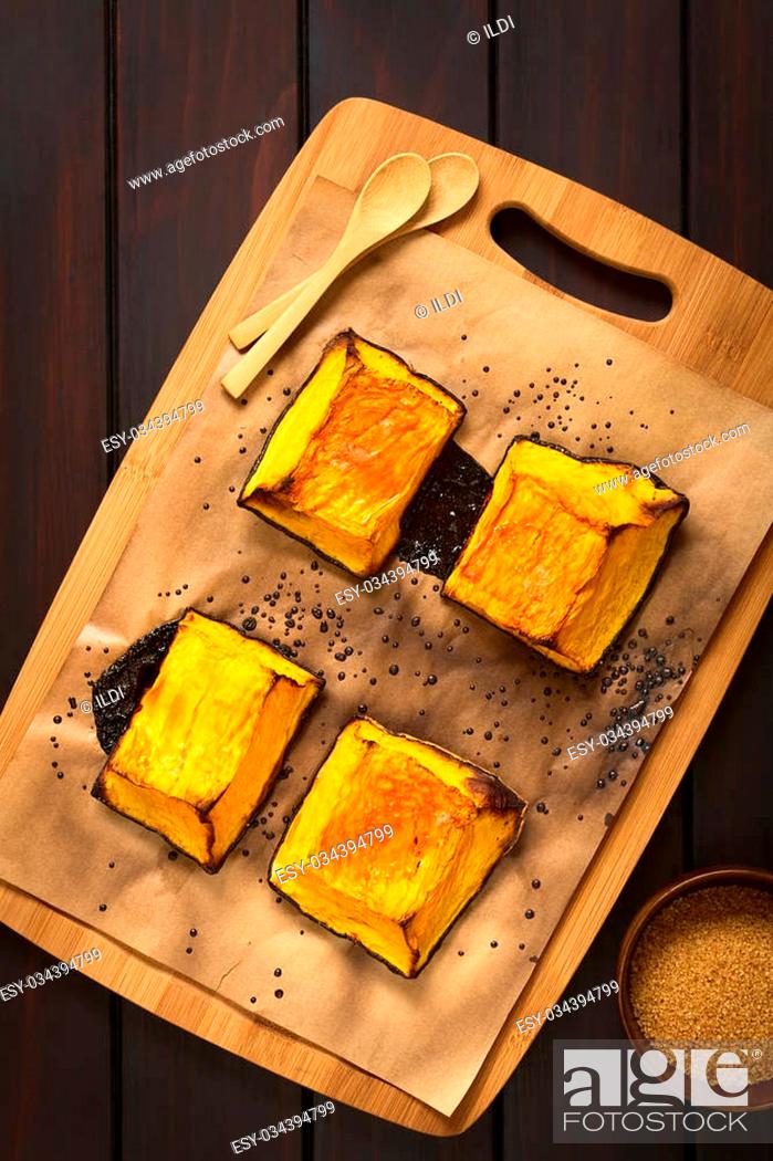 Stock Photo: Baked pumpkin pieces with caramelized sugar on top, a traditional autumn snack in Hungary, photographed overhead on dark wood with natural light.