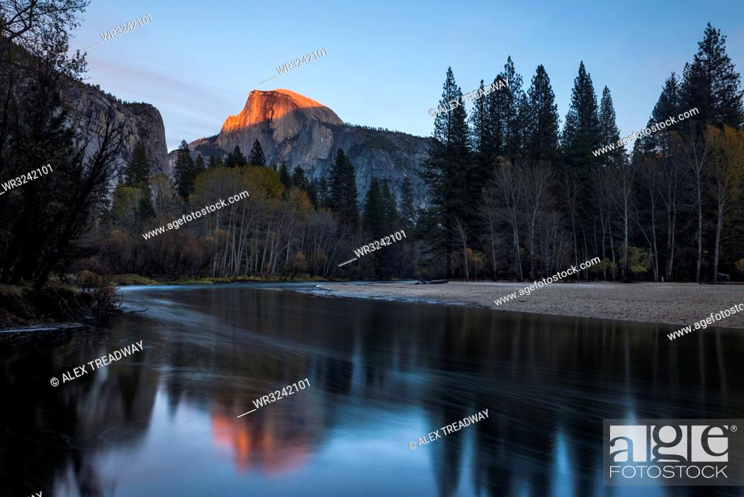 Stock Photo: Half Dome mountain catches the last glow of sunset reflected in the Merced river in Yosemite National Park, UNESCO World Heritage Site, California.