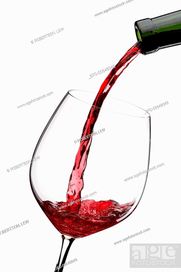 Stock Photo: Pouring Red Wine from a Bottle into a Glass.