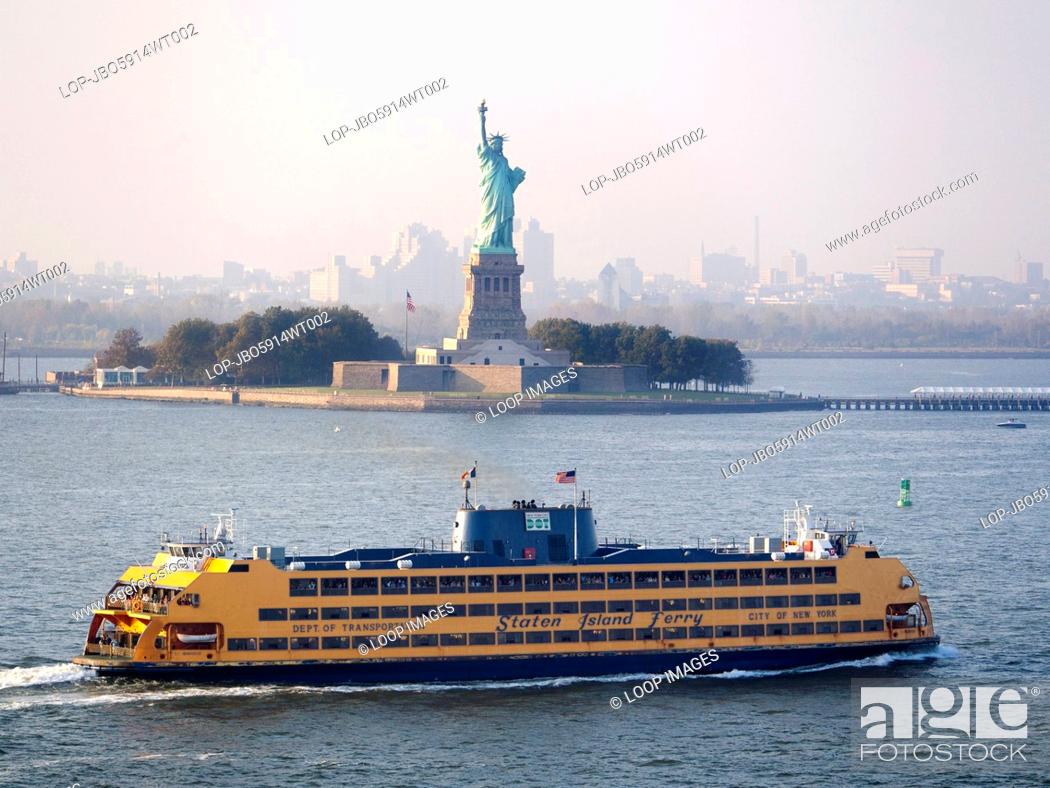 Stock Photo: A Staten Island ferry passing the Statue of Liberty.