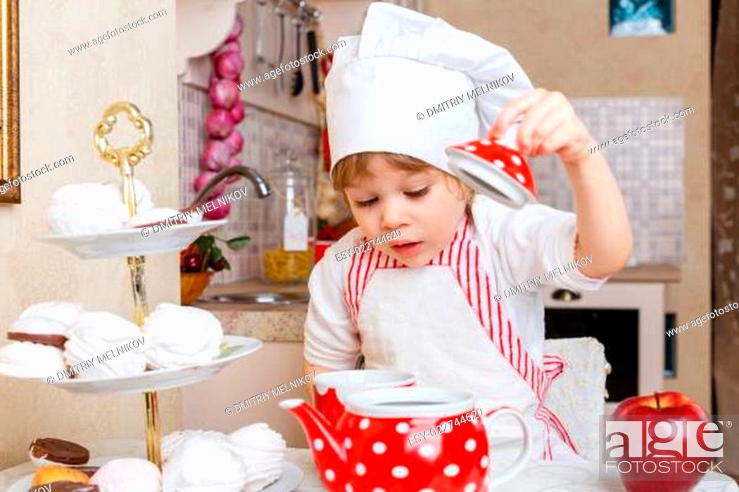 Stock Photo: Little girl in apron in the kitchen.