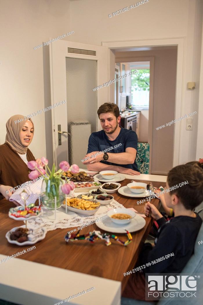 Stock Photo: PRODUCTION - 10 May 2021, North Rhine-Westphalia, Minden: Hatice Bahadir (l-r), Abdurrahman Bahadir and their children have an iftar (breaking of the fast) meal.