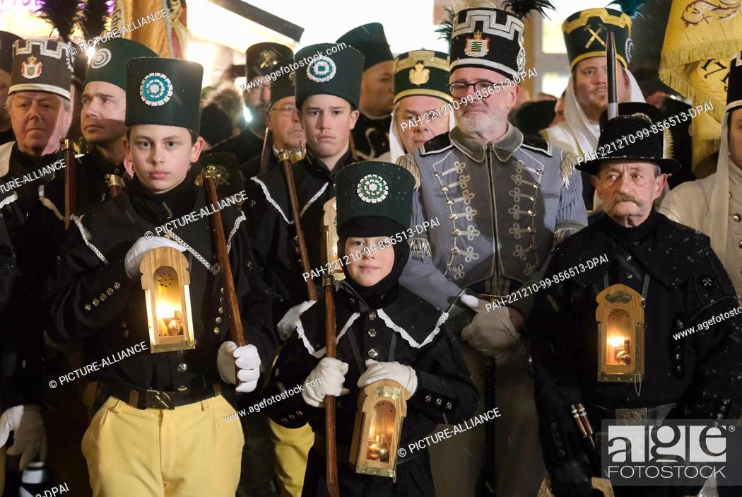 Stock Photo: 10 December 2022, Saxony, Oberwiesenthal: Actors from miners' clubs stand in the market square. A traditional mining parade took place there.