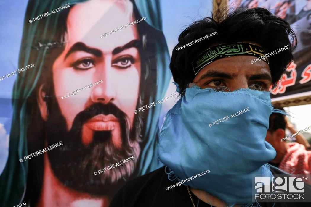 Stock Photo: 01 October 2021, Iraq, Baghdad: An Iraqi demonstrator is seen backdropped with a picture of Imam Husayn Ibn Ali, grandson of Islam's Prophet Muhammad.