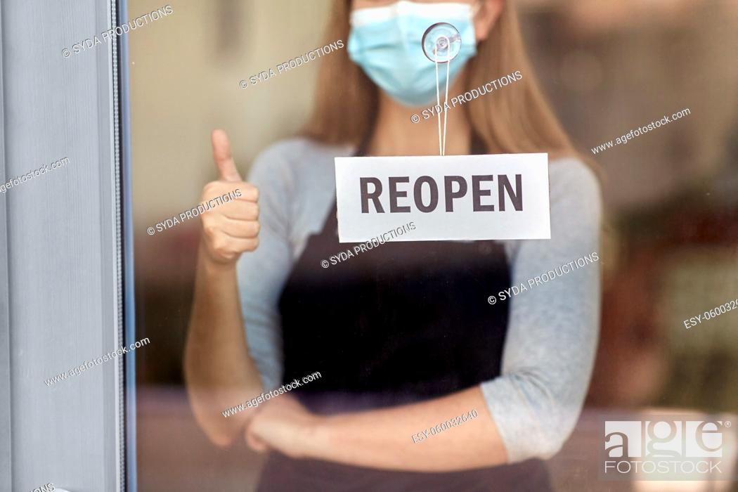Stock Photo: woman in mask with reopen banner showing thumbs up.