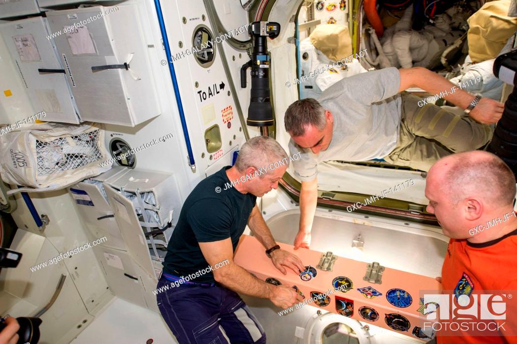 Stock Photo: In the Unity node, NASA astronaut Steve Swanson (left), Expedition 40 commander, adds the Expedition 40 patch to the growing collection of insignias.
