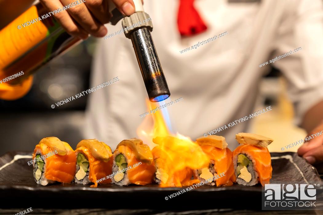 Stock Photo: Chef cooking Salmon Foie gras roll, Fusion Japanese Cuisine food, using gas burner torch.