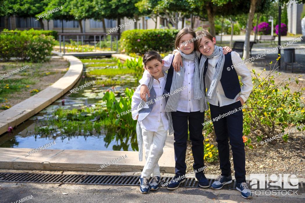 Photo de stock: Three boys pose showing joy, casual and embraced, copy-space.